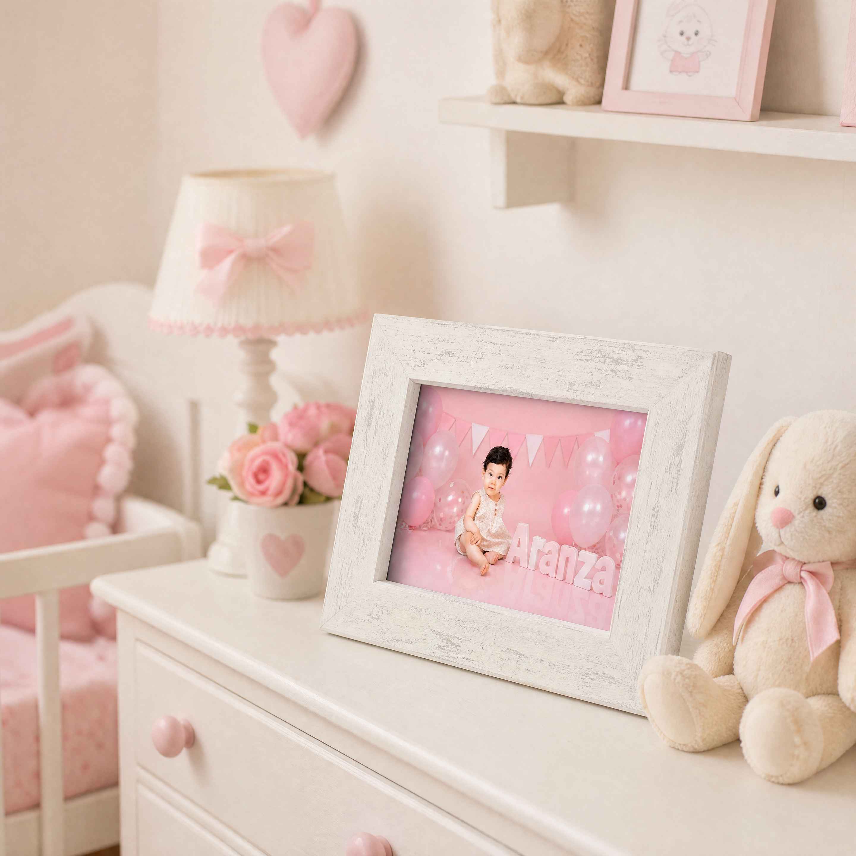 Retrato infantil enmarcado en moldura blanca sobre tocador rosa